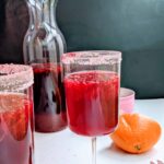 orange hibiscus cooler in wine glasses with a carafe