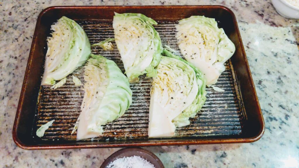 cabbage wedges with pepper on a pan